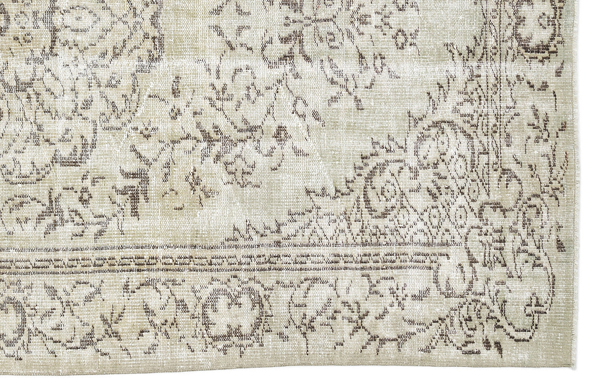 Beige and taupe rug with a distressed traditional floral medallion pattern and a fringed edge.