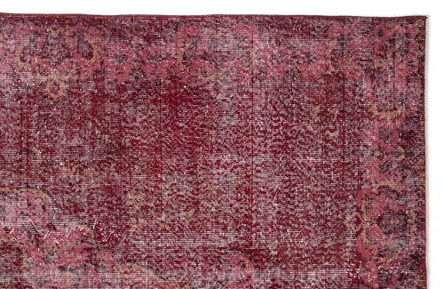 Load image 1 in gallery view. Deep red distressed rug with a faded traditional floral medallion pattern.