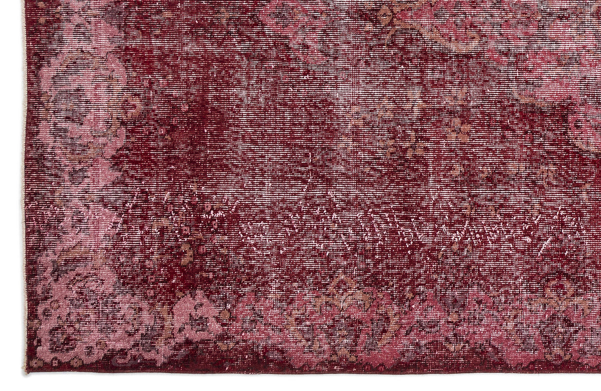 Deep red and pink distressed traditional rug with a faded floral medallion pattern.