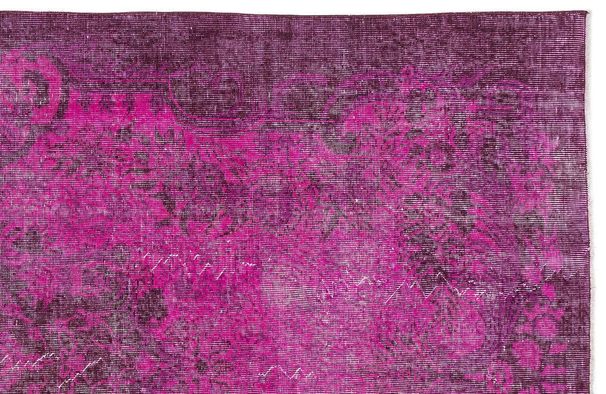 Magenta and deep purple distressed rug with a faded traditional floral pattern.