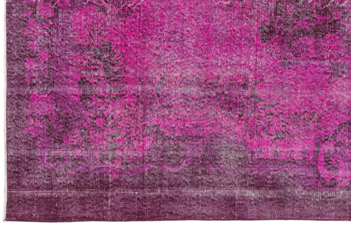 Magenta and deep purple distressed rug with a faded traditional floral medallion pattern.