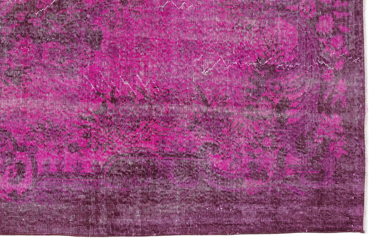 Magenta and deep purple distressed rug with a traditional floral medallion pattern.