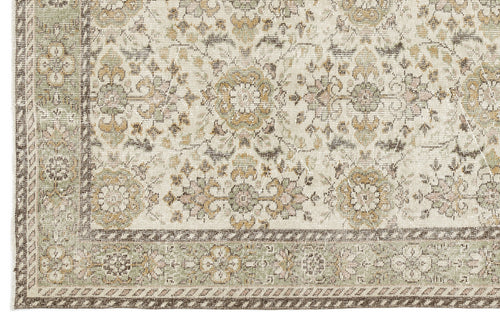 Load image 1 in gallery view. A close-up of the Nizora - Vintage Floral Rug (6'1 x 10'0) shows its beige background with floral and geometric patterns in muted green, brown, and gold tones, framed by a decorative border.