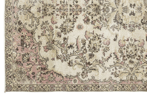 Load image 1 in gallery view. Distressed beige rug with a faded floral medallion pattern in muted pink and dark brown.