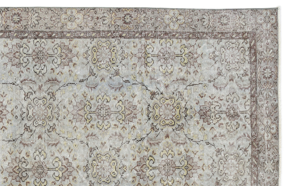 Grey and beige traditional rug with a distressed floral medallion pattern and a detailed border.