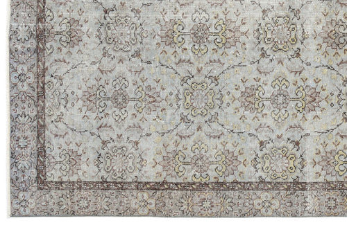 Load image 1 in gallery view. Light gray rug with a distressed traditional floral medallion pattern in muted brown and yellow tones.