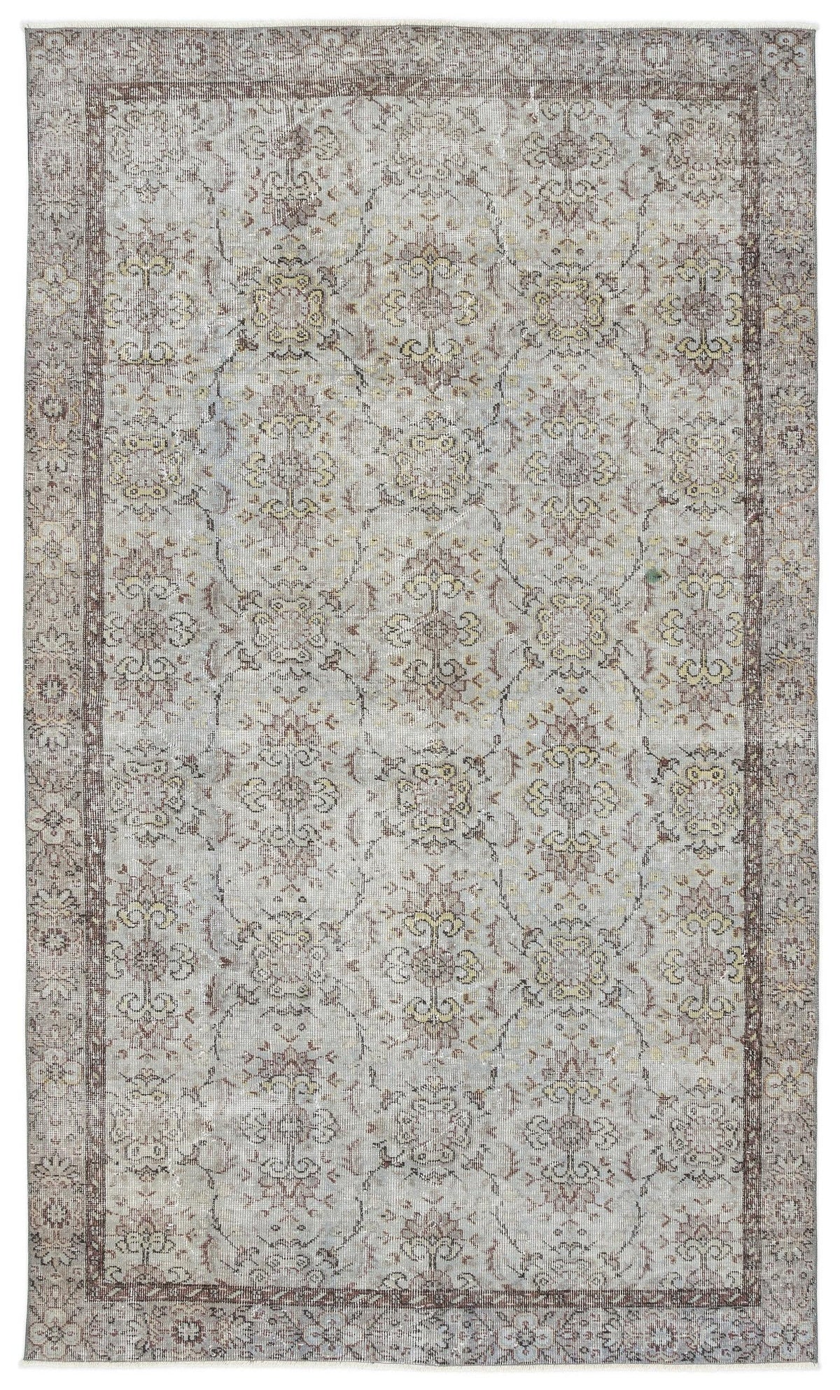Distressed light gray rug with a faded brown and yellow floral medallion pattern and a dark brown border.