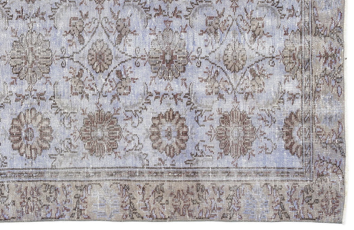 Light blue and taupe distressed rug with a traditional floral medallion pattern and a wide decorative border.