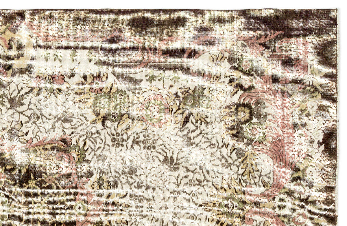 Distressed brown, cream, and muted pink rug with an intricate floral medallion pattern on a white background.