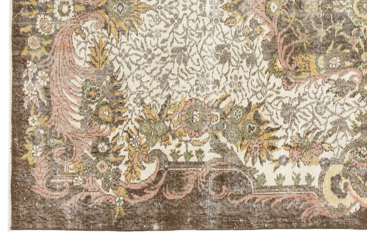 Brown, cream, and muted pink traditional floral medallion rug with a distressed, vintage-style finish.