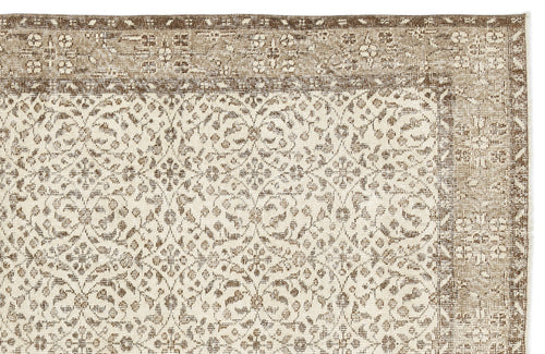 Load image 1 in gallery view. Beige and brown rug with a distressed, repeating floral medallion pattern and a decorative border.