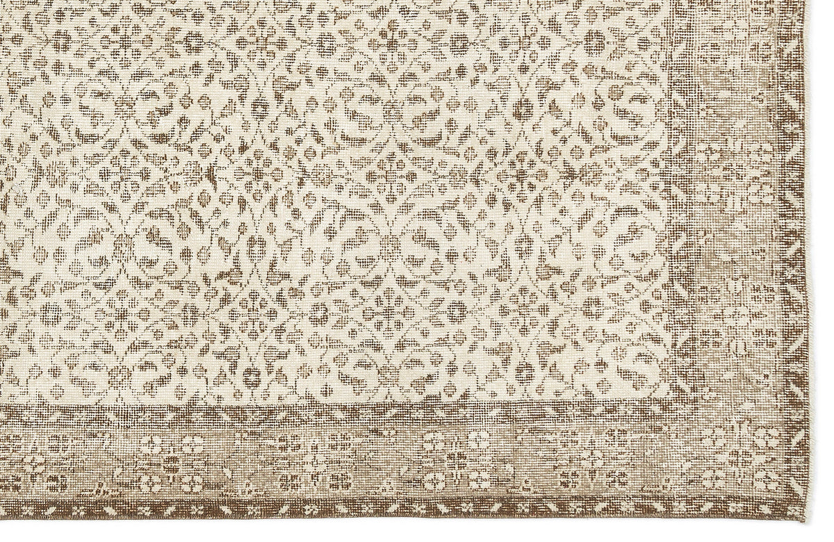 Beige and cream rug with a distressed floral medallion pattern and a wide, detailed border.
