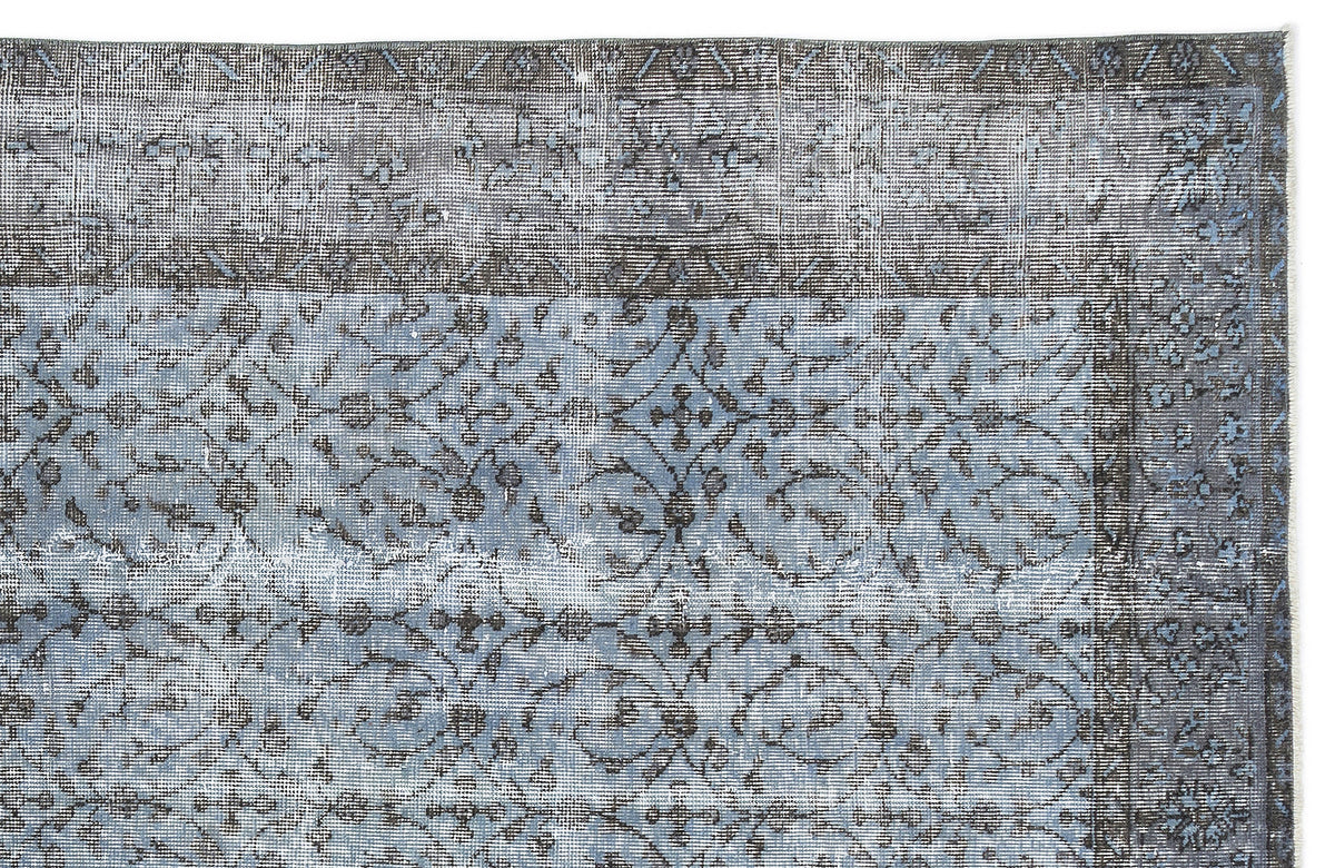 Blue and charcoal grey distressed rug with a traditional floral medallion pattern and a wide decorative border.