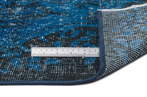 Load image 1 in gallery view. Blue and black distressed pattern rug with a folded corner and a metal ruler for scale on a white background.