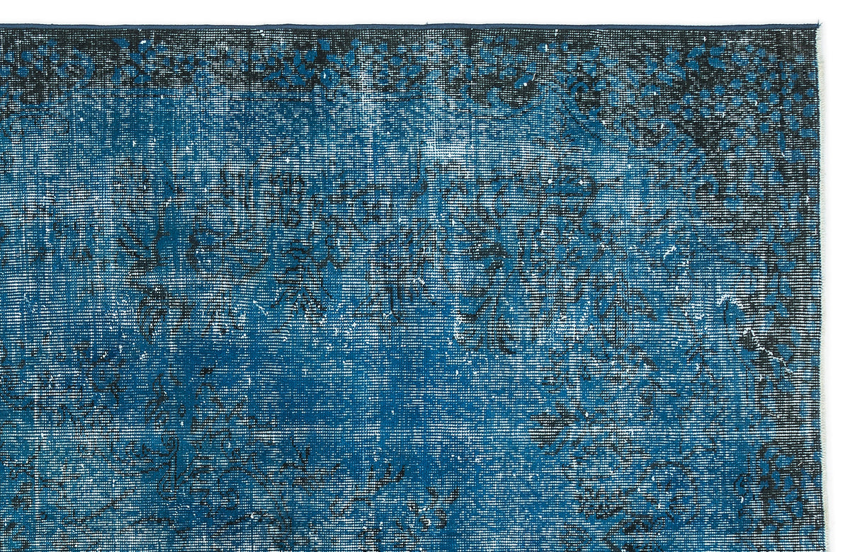 Deep blue and black distressed rug with a faded traditional floral pattern on a white background.