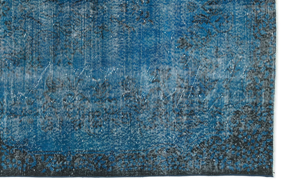 Deep blue distressed rug with a faded black traditional floral pattern and a solid dark border.