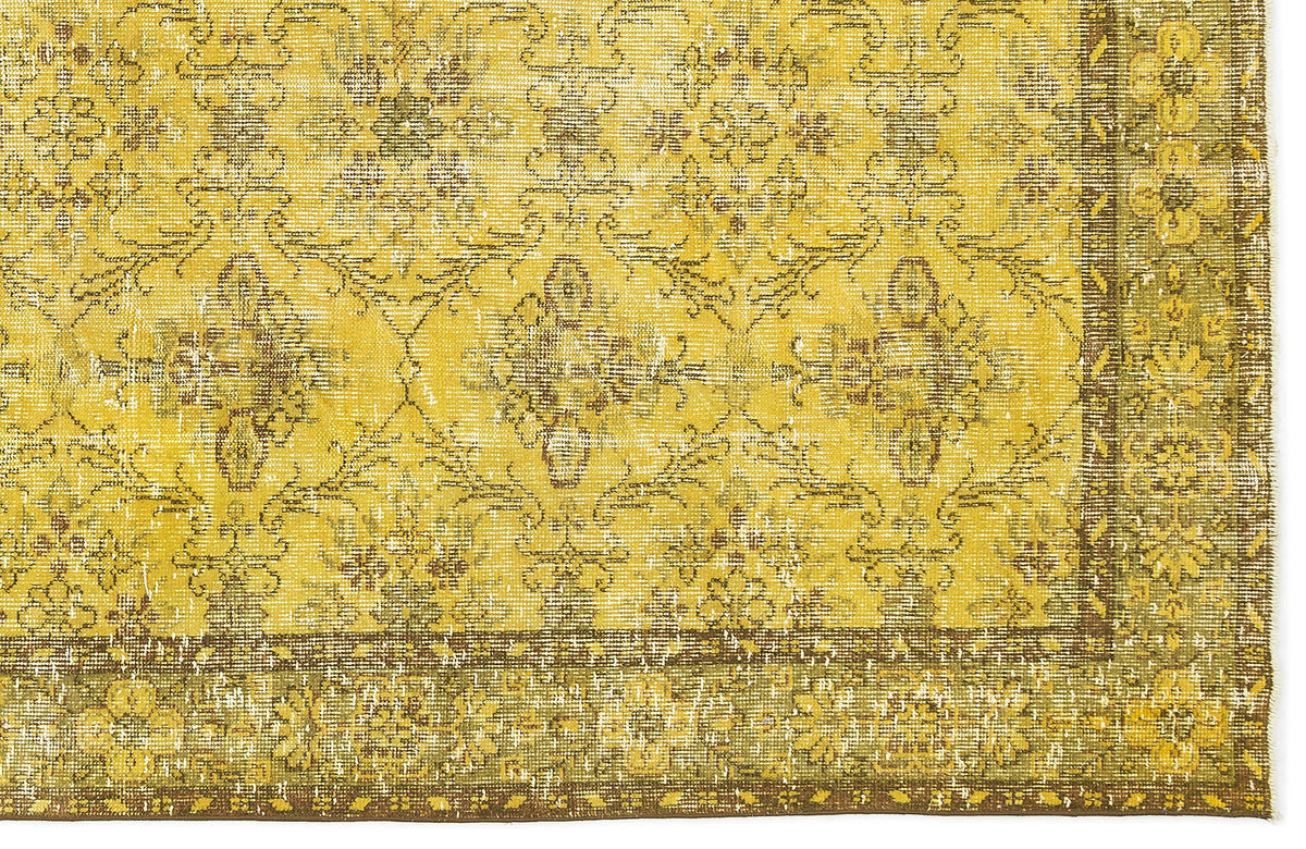 Mustard yellow and brown distressed rug with a traditional floral medallion pattern and a decorative border.