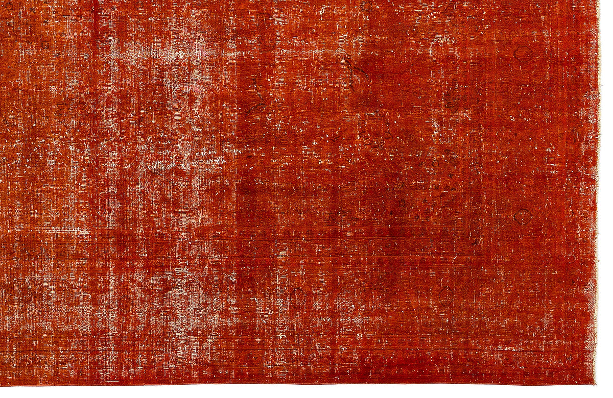 Burnt orange distressed rug with a faded, traditional overdyed pattern on a white background.