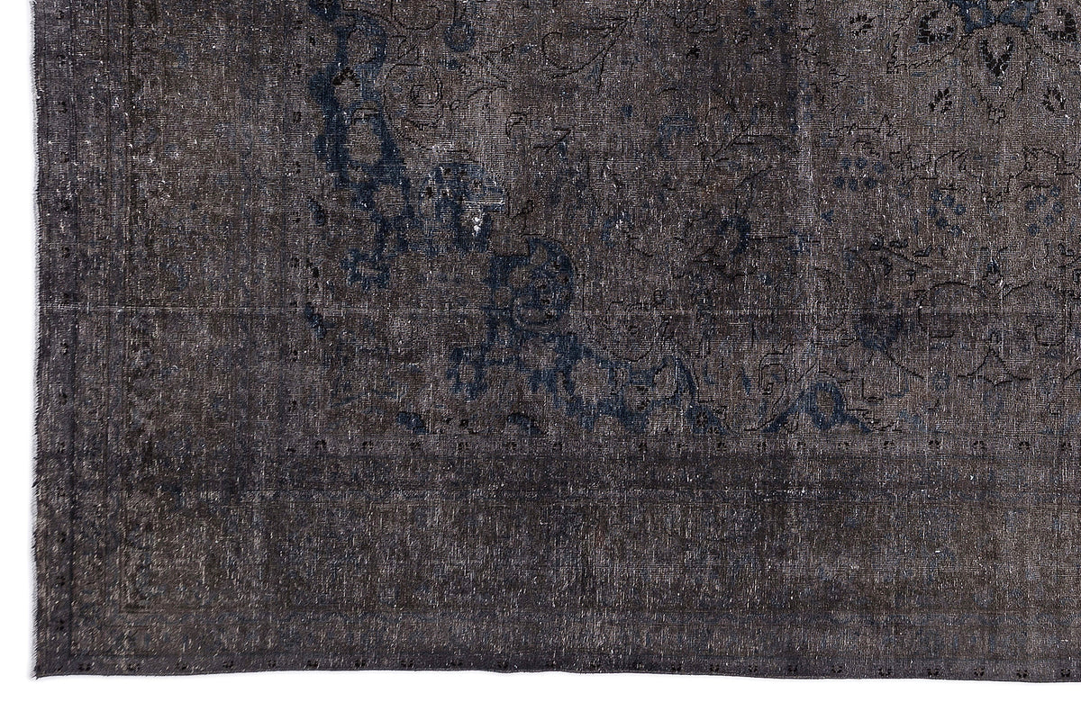 Charcoal and navy blue distressed rug with a faded traditional floral medallion pattern.