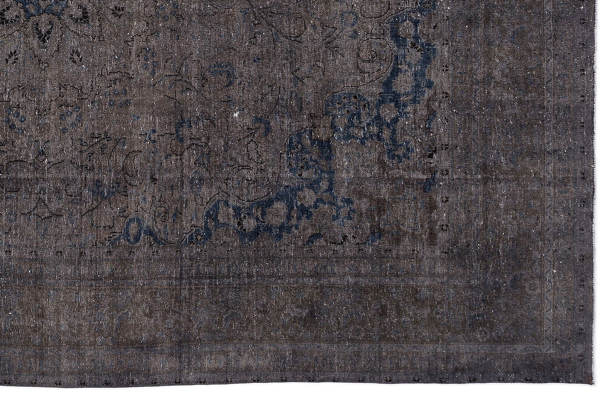 Charcoal and navy blue distressed rug with a faded traditional floral medallion pattern.