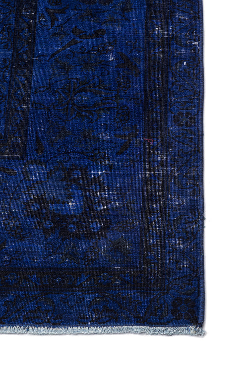 Load image 1 in gallery view. Deep blue and black distressed traditional rug with a faded floral medallion pattern and fringed edge.