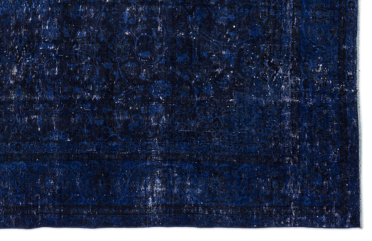 Deep blue distressed rug with a faded traditional floral medallion pattern and a dark border.
