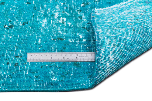 Load image 1 in gallery view. Distressed turquoise rug with white and dark green accents, shown with a metal ruler for scale.