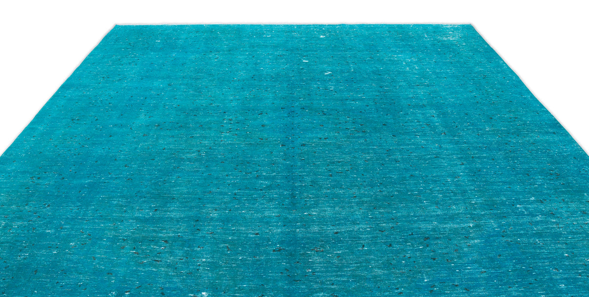 Solid turquoise rug with a distressed, weathered texture and subtle dark flecks on a white background.