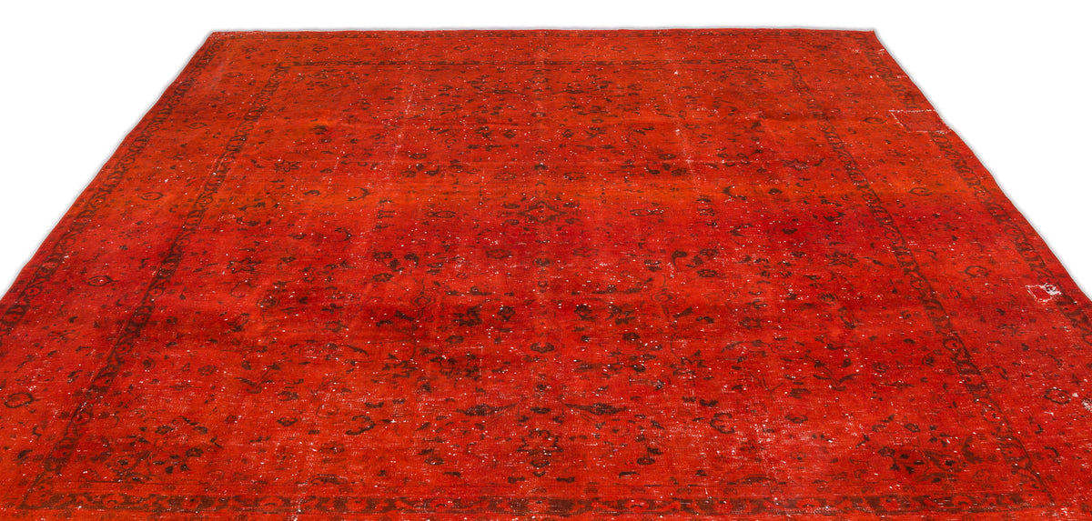 Distressed red rug with a faded black traditional floral medallion pattern and a wide border.