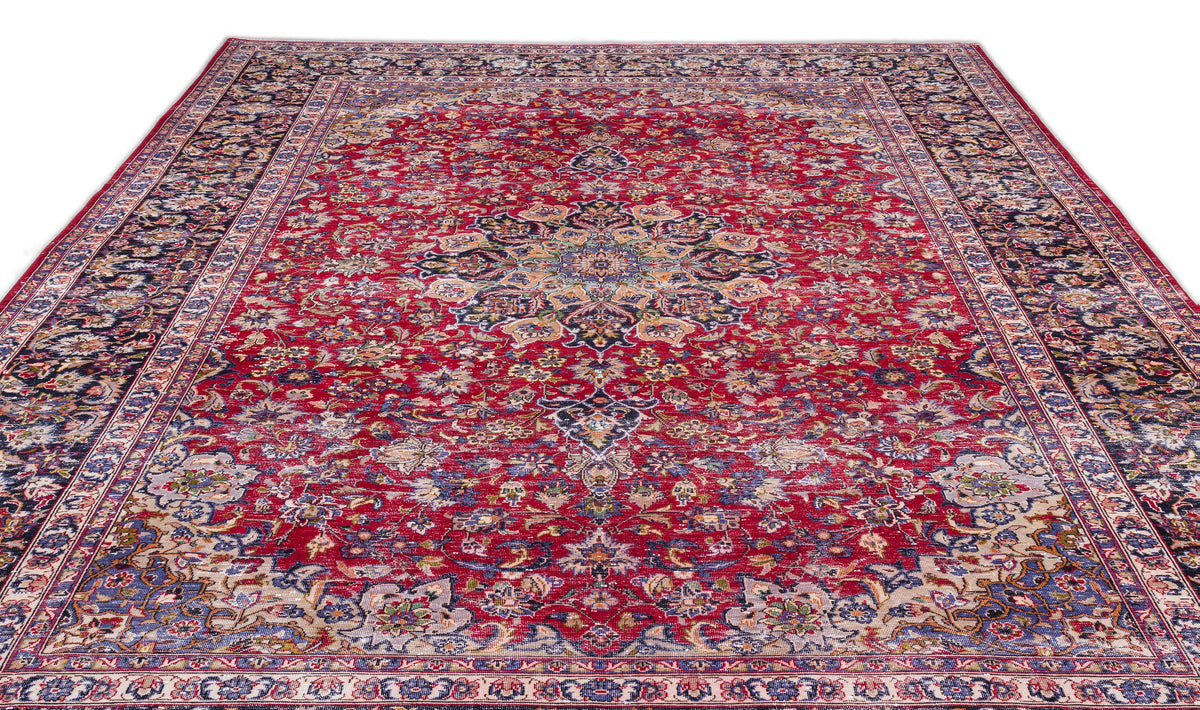Red traditional Persian-style rug with a central floral medallion, intricate navy and cream borders, and distressed finish.