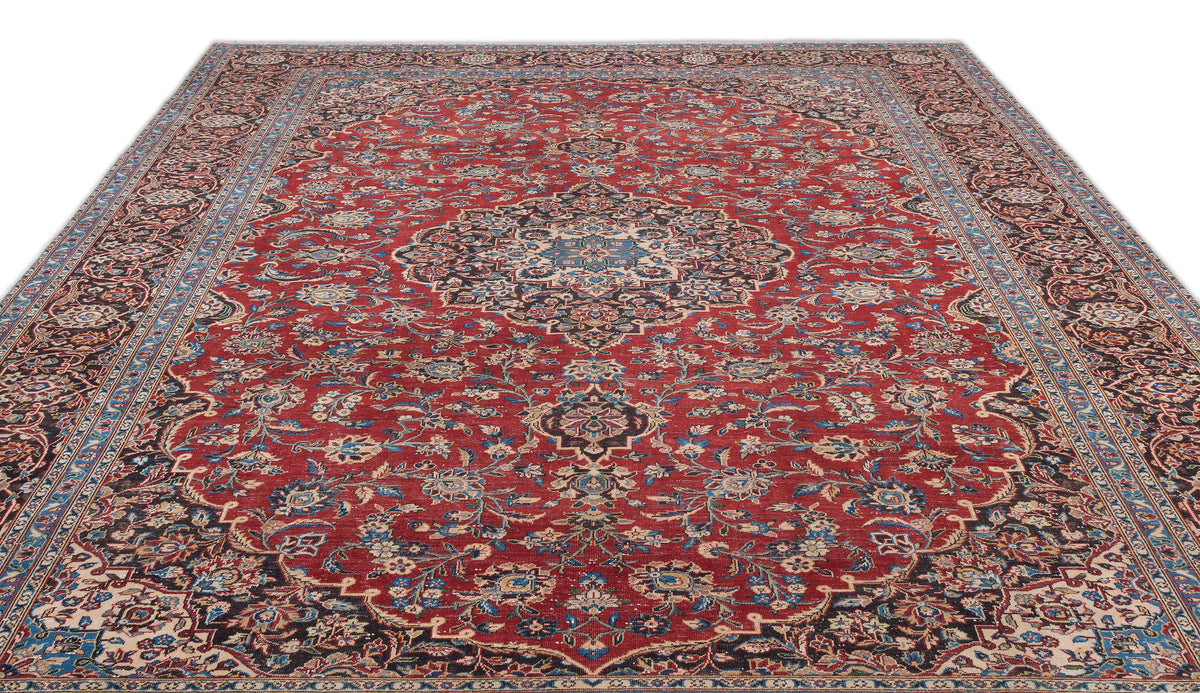Red traditional Persian-style rug with a central floral medallion, intricate blue and cream patterns, and a wide border.