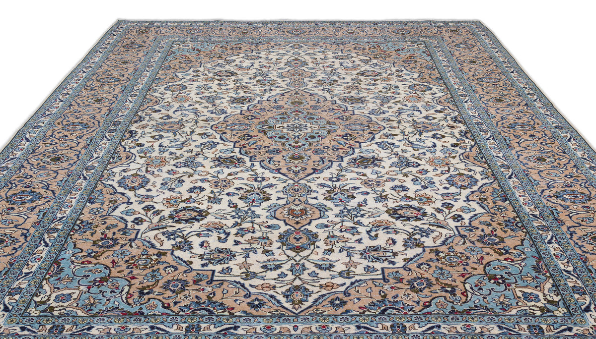 Cream, blue, and tan traditional Persian-style rug with a central floral medallion and intricate botanical border.