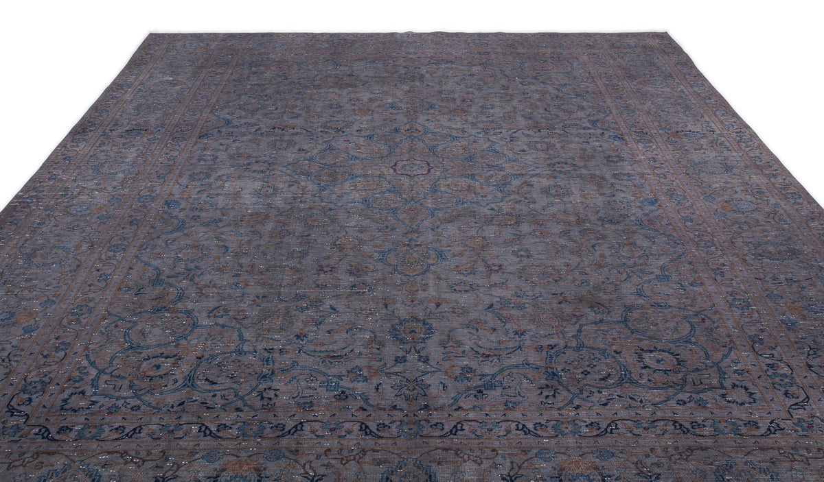 Distressed charcoal and blue traditional rug with a central floral medallion and intricate border on a white background.