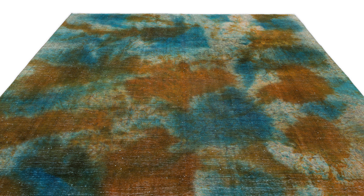 Blue and copper abstract rug with a distressed, cloud-like watercolor pattern on a white background.