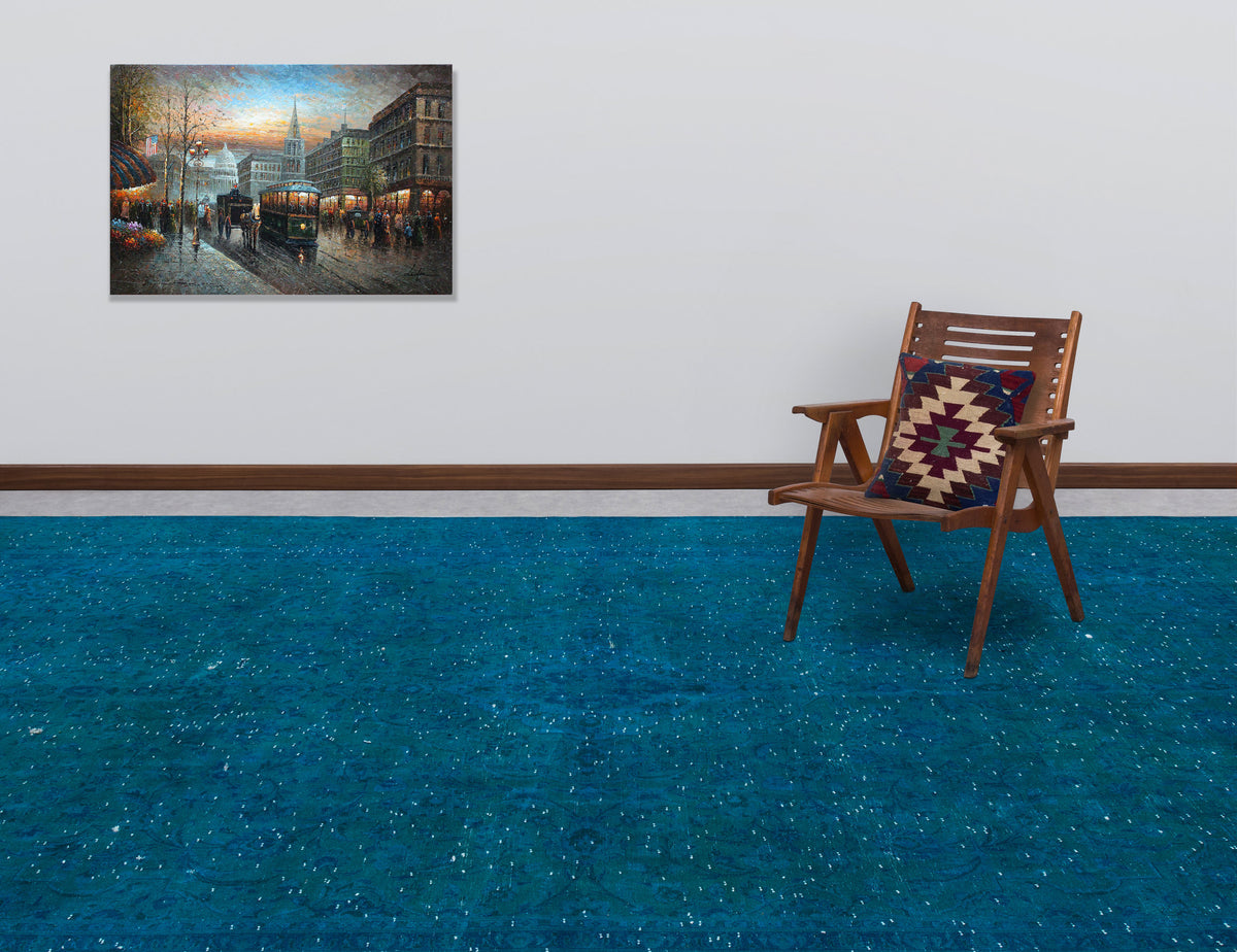 Solid teal distressed-style rug with subtle tonal patterns, styled in a room with a wooden chair and wall art.