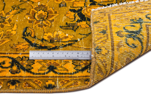 Load image 1 in gallery view. Mustard yellow and black traditional floral rug with a distressed finish, shown folded with a metal ruler for scale.