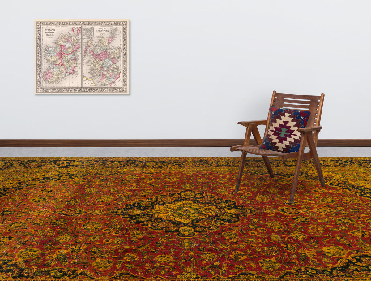 Red, gold, and black traditional medallion rug in a room with a wooden chair and a vintage map on the wall.