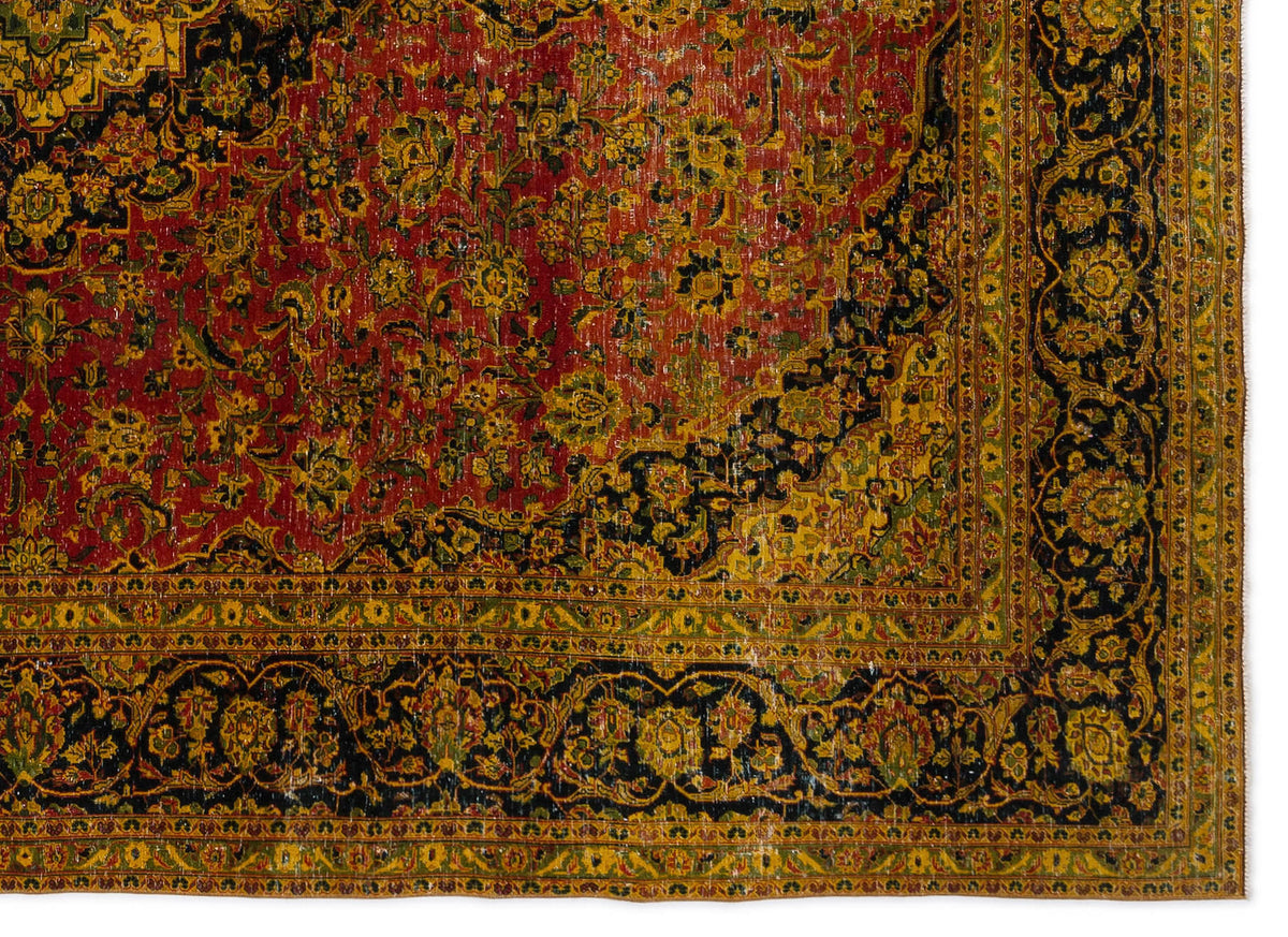 Distressed traditional rug with a red field, black borders, and intricate yellow and green floral medallion patterns.