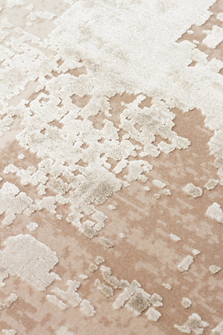 Beige and cream rug with a high-low pile, featuring an abstract, distressed, and textured pattern.