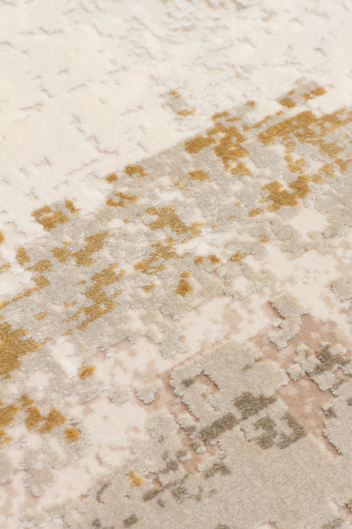Cream, beige, and ochre rug with a distressed, abstract textured pattern.