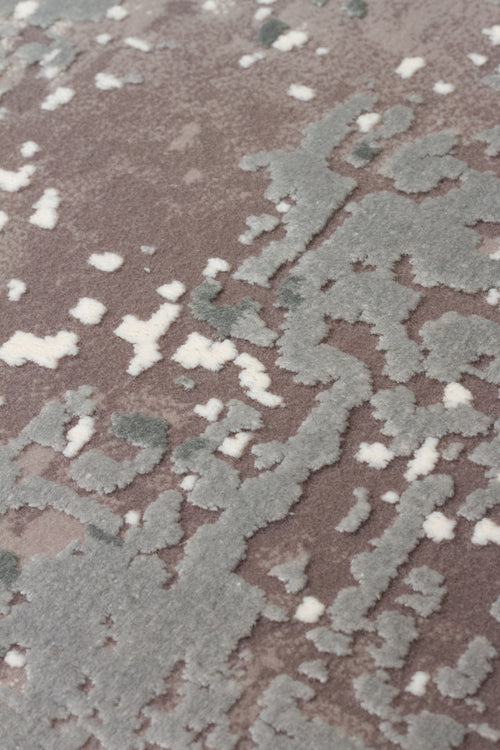 Load image 1 in gallery view. Close-up of a taupe rug with a raised, textured abstract pattern in sage green and cream.