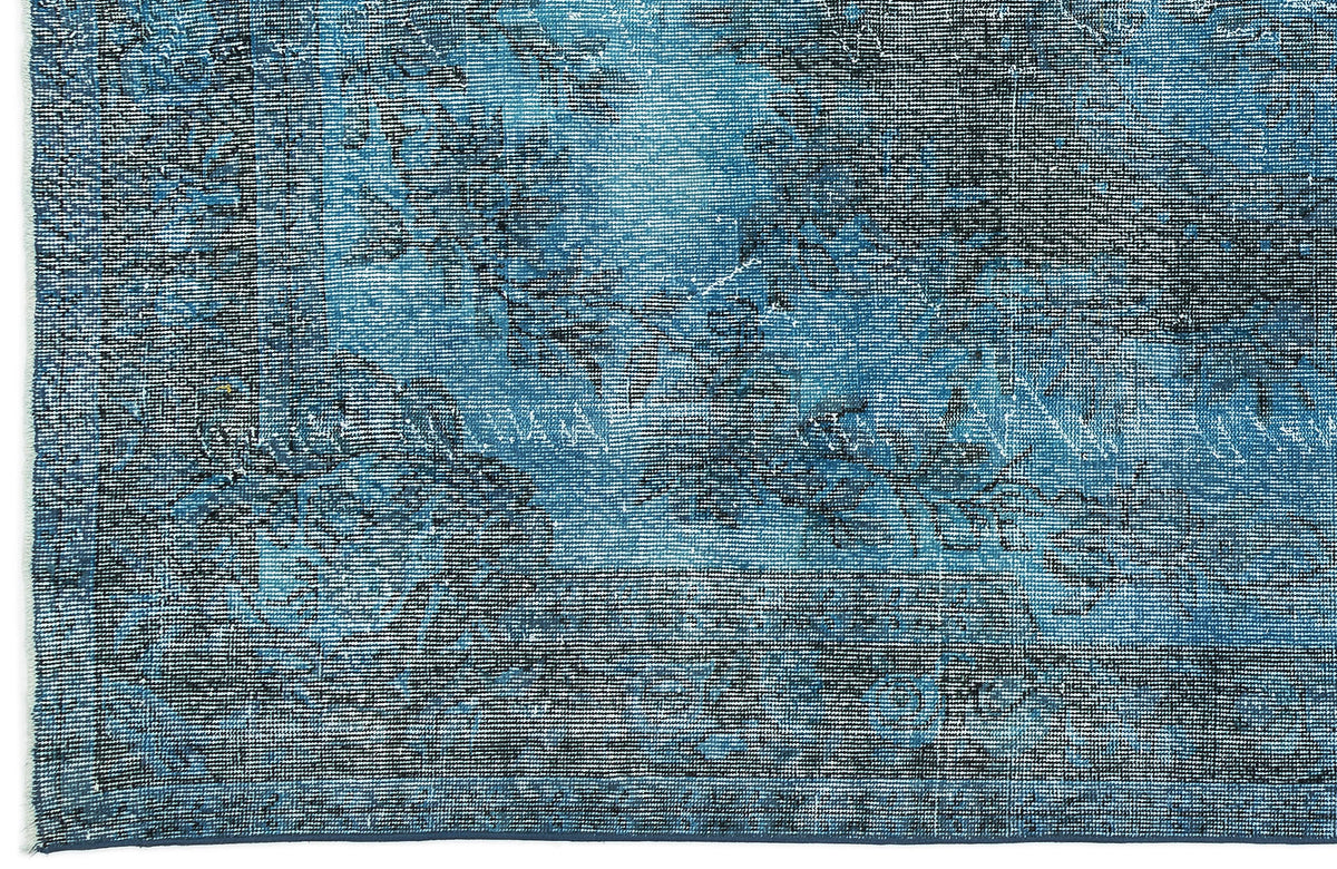 Deep blue and black distressed rug with a faded traditional floral medallion pattern.