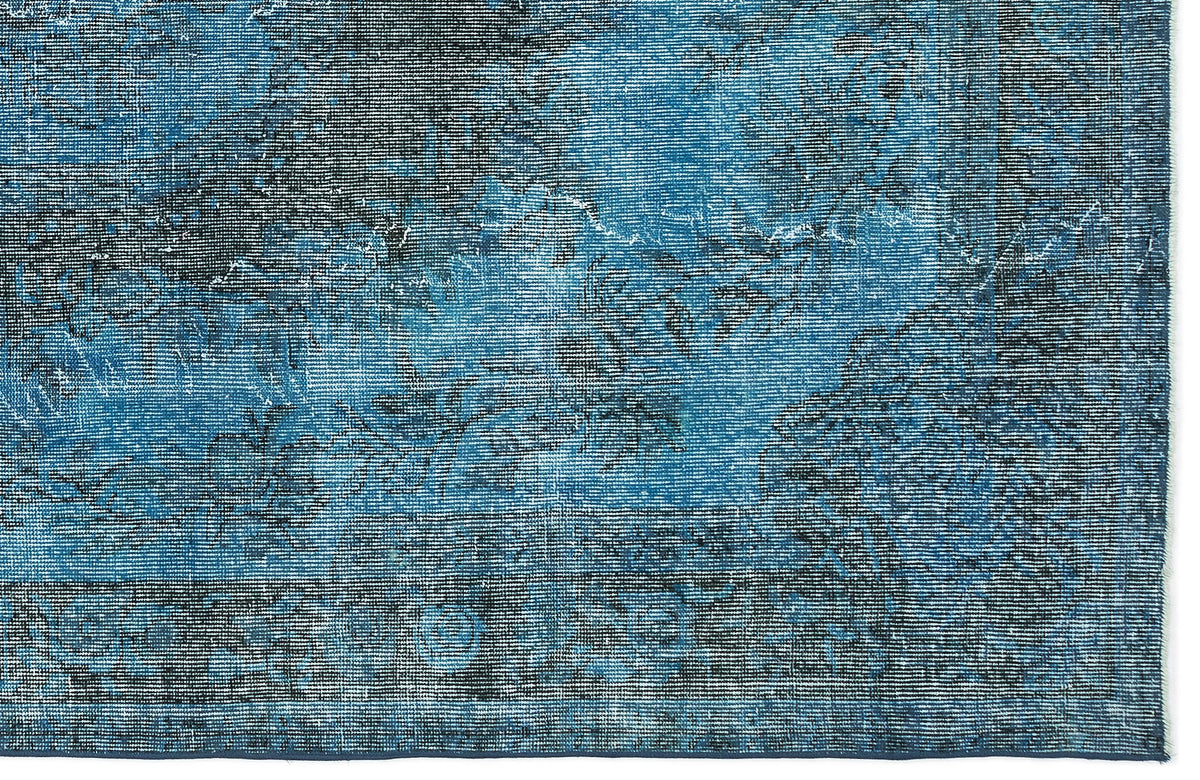 Blue and black distressed rug with a faded traditional medallion pattern and a dark border.
