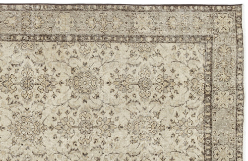 Load image 1 in gallery view. A close-up of the Kemora - Vintage Floral Rug (4'10 X 8'6) shows its beige and brown tones, ornate faded floral and vine pattern, decorative border, and vintage distressed design.