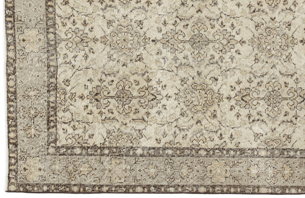 Close-up of the Kemora - Vintage Floral Rug (4'10 X 8'6), showcasing a beige and brown Anatolian-inspired pattern with intricate, symmetrical florals and vines, bordered by smaller motifs and finished in a vintage, distressed style.