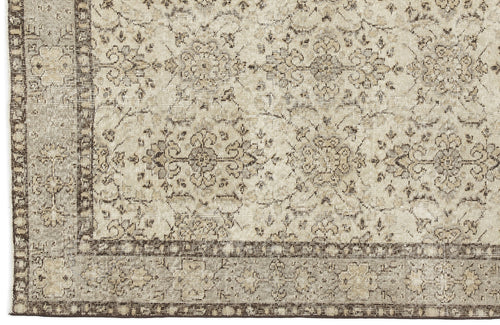 Load image 1 in gallery view. Close-up of the Kemora - Vintage Floral Rug (4'10 X 8'6), showcasing a beige and brown Anatolian-inspired pattern with intricate, symmetrical florals and vines, bordered by smaller motifs and finished in a vintage, distressed style.