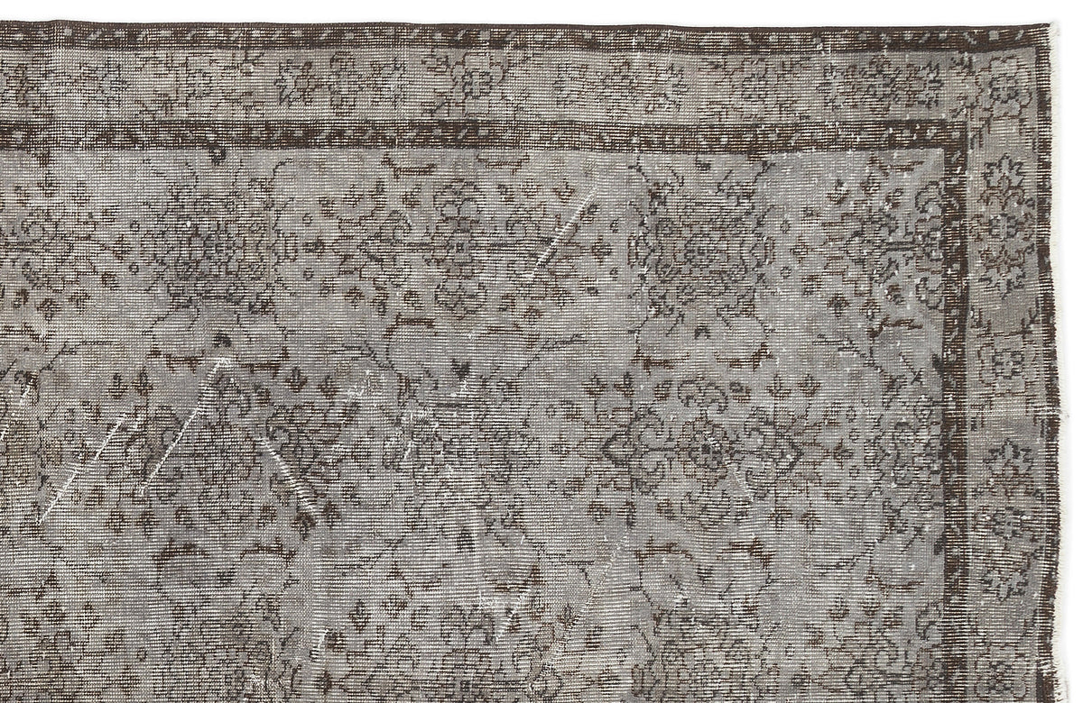 Grey and dark brown distressed rug with a traditional floral medallion pattern and a detailed border.