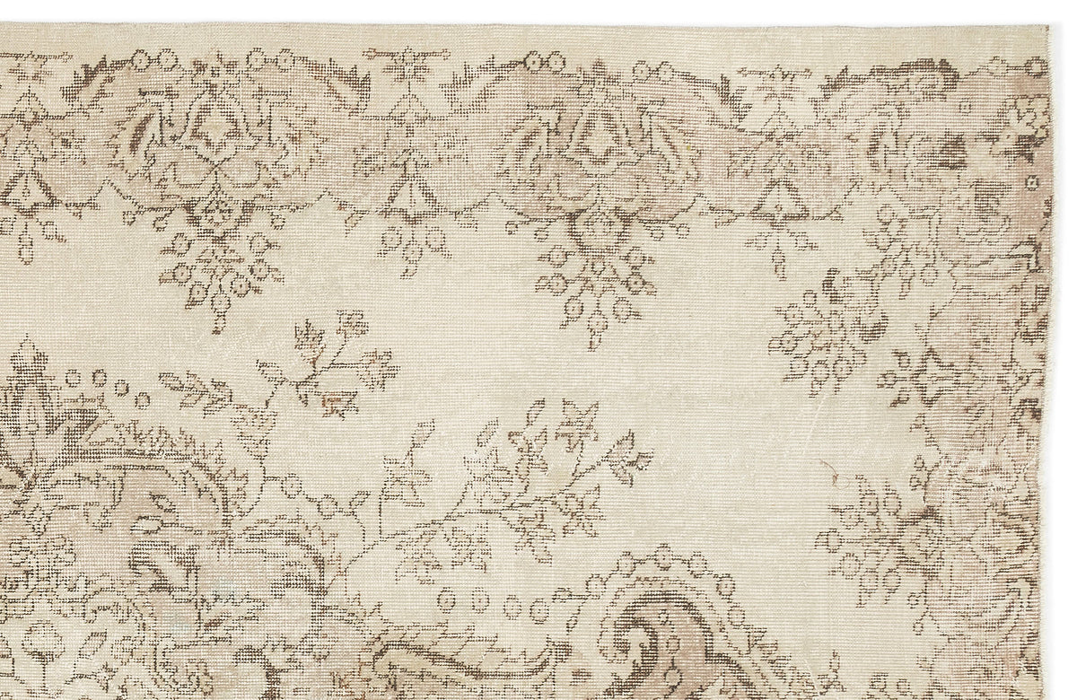 Beige and taupe vintage-style rug with a faded floral and paisley pattern on a white background.