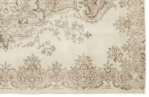 Load image 1 in gallery view. Cream and beige rug with a distressed, faded floral medallion pattern.
