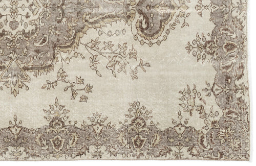 Load image 1 in gallery view. A section of the Luboane Vintage Medallion Rug (6'1 x 9'1) displays a faded beige and brown floral vine design with a decorative border, featuring intricate, slightly distressed patterns for an authentic vintage overdyed look.